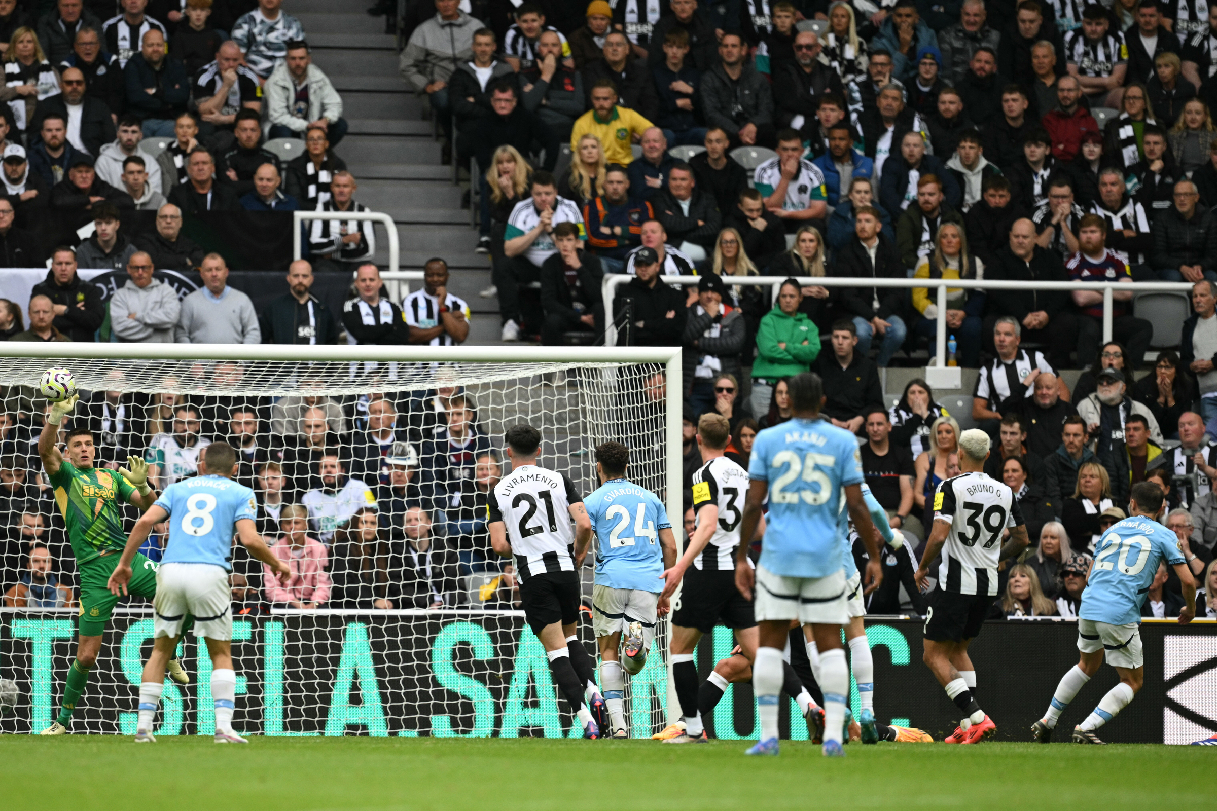 Thủ môn Nick Pope (áo xanh) đấm bóng cản phá cú sút của Bernardo Silva (số 20) trong trận hòa 1-1 trên sân St James Park ở vòng 6 Ngoại hạng Anh hôm 28/9. Ảnh: AFP