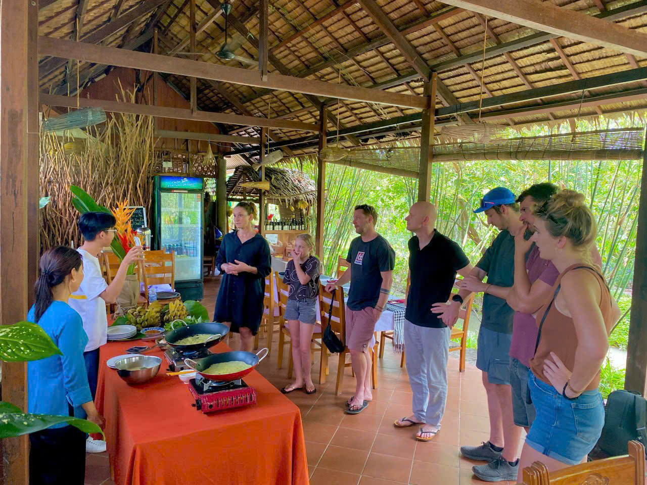 Du khách nước ngoài trải nghiệm làm bánh xèo tại khu nghỉ dưỡng ở Cần Thơ. Ảnh: Mekong Silt Ecolodge